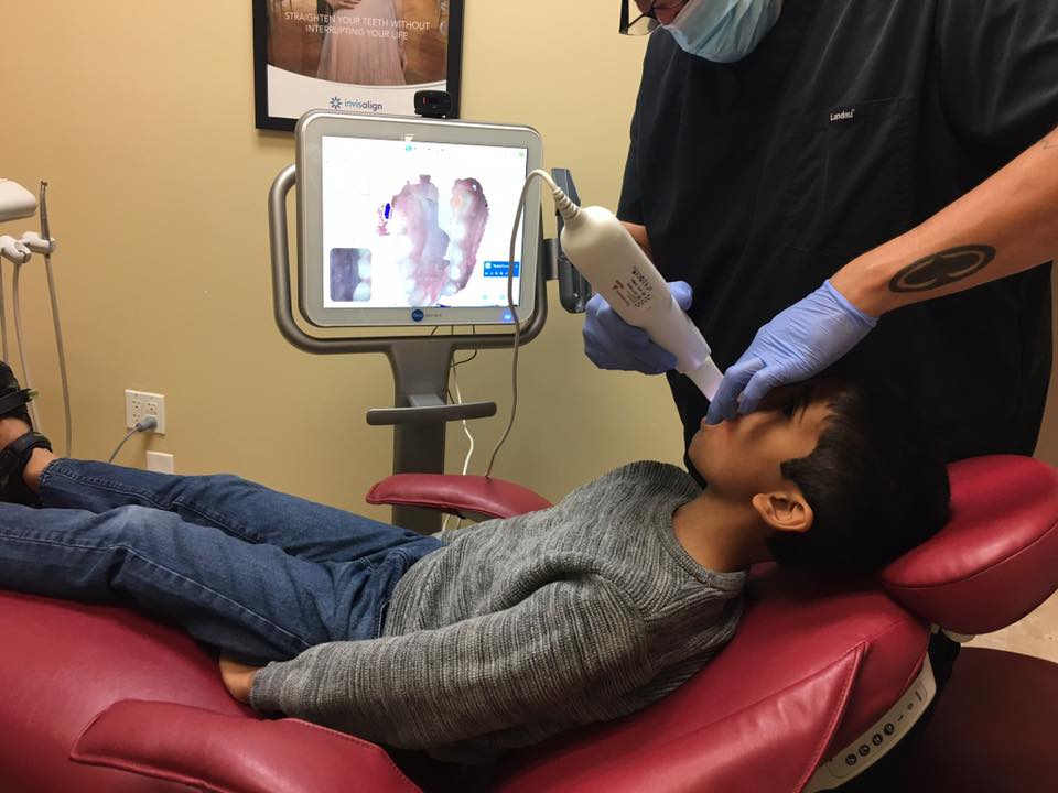 Patient receiving an iTero 3D intraoral scan in front of an Invisalign display — Invisalign provider at Natural Smiles Dentistry, Chandler AZ